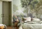 Green foggy forest wall mural with tropical leaves behind a sage sofa and armchair