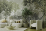 Green foggy forest wall mural with tropical leaves behind a sage sofa and armchair