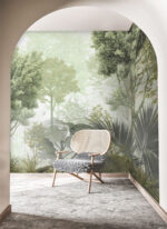 Green foggy forest wall mural with tropical leaves behind a sage sofa and armchair